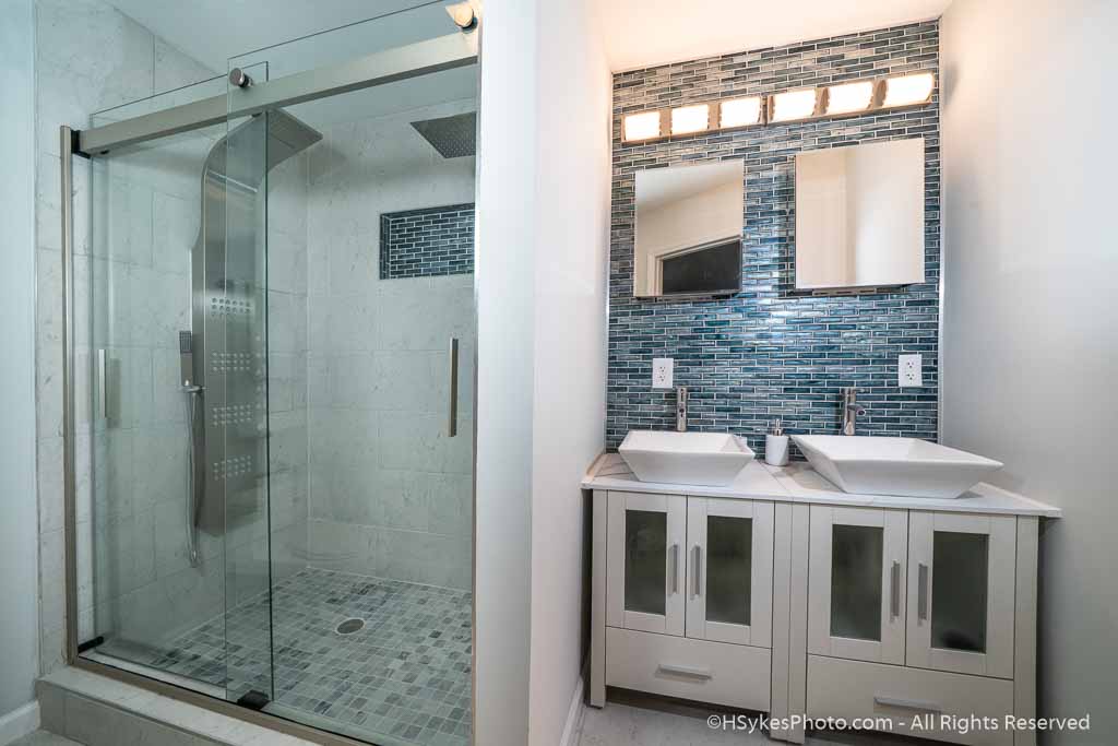 Master bathroom including dual sinks and sliding glass shower doors